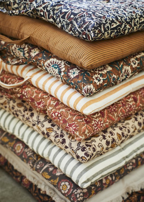 A pile of colorful cotton mattress pillows with flowers and stripes