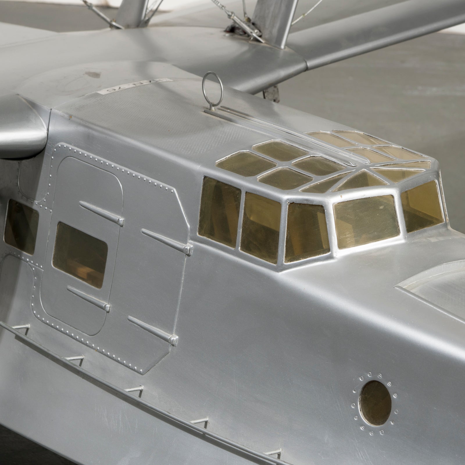 Close-up of the cockpit of a large vintage model of a World War I-era airplane with a silver finish