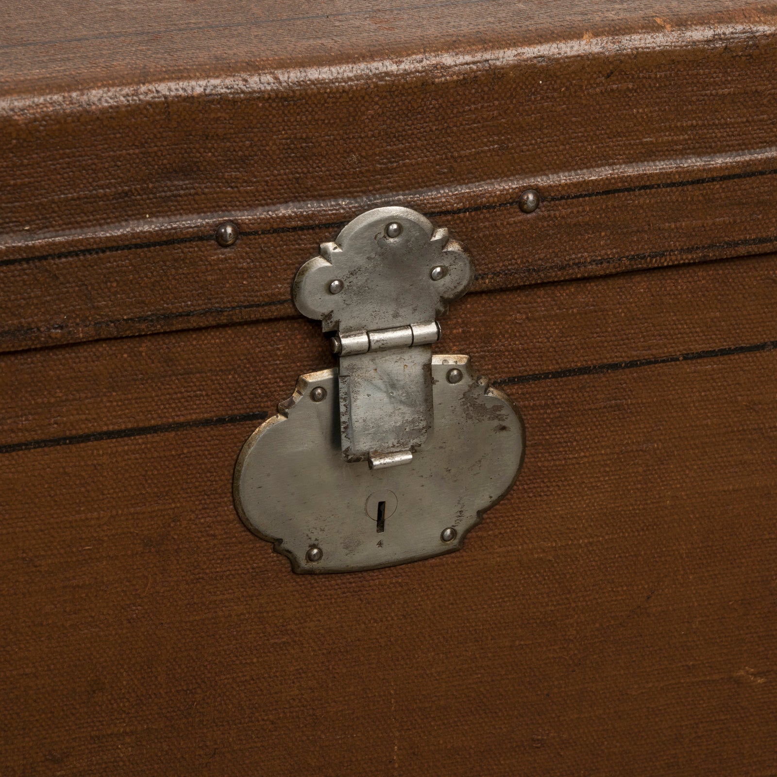 Close-up of a lock belonging to a brown vintage canvas cube-shaped trunk
