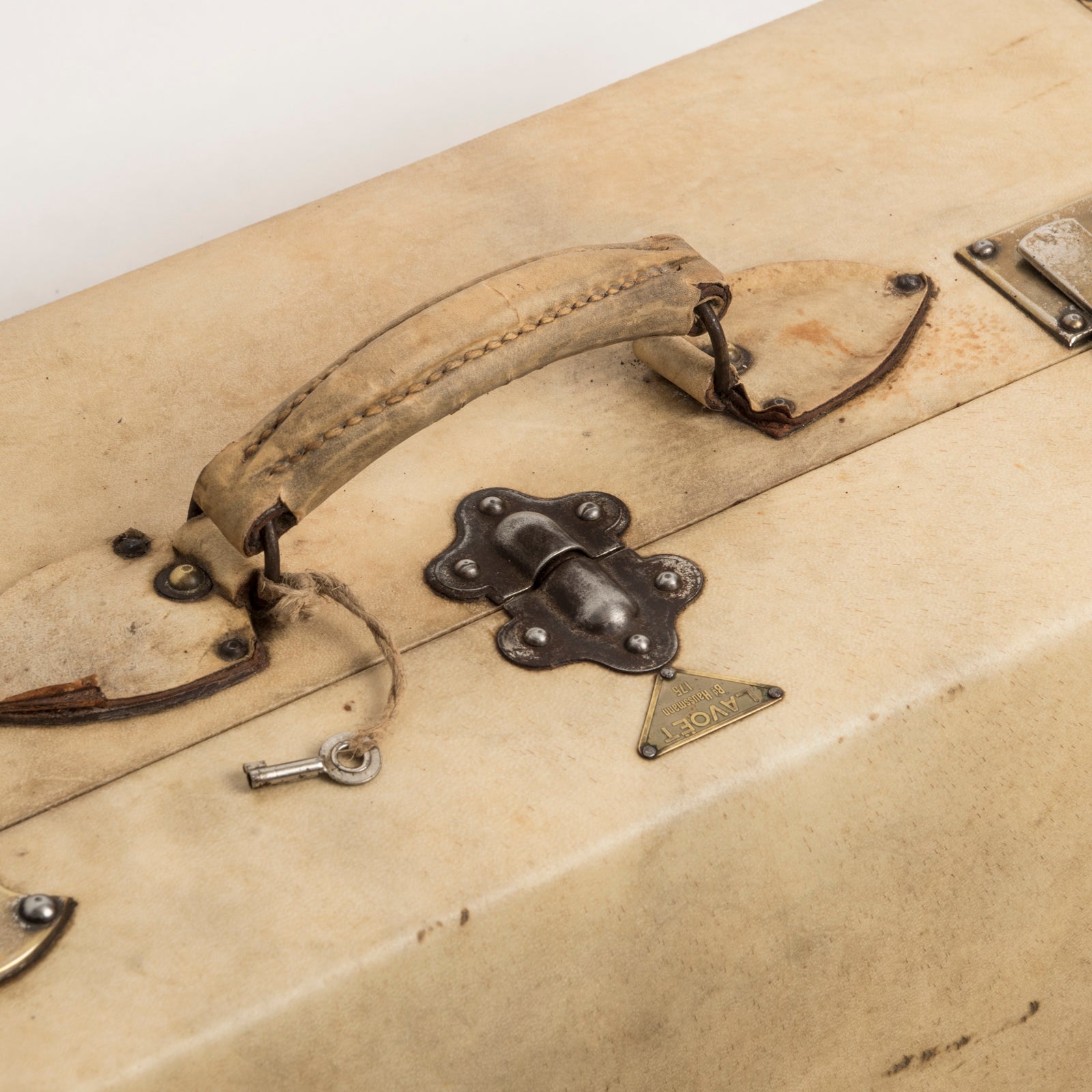 Top view of a vintage French cream leather suitcase with brass studs, leather handle, and a lock plate by Lavoet, available at Wildschut Antiques