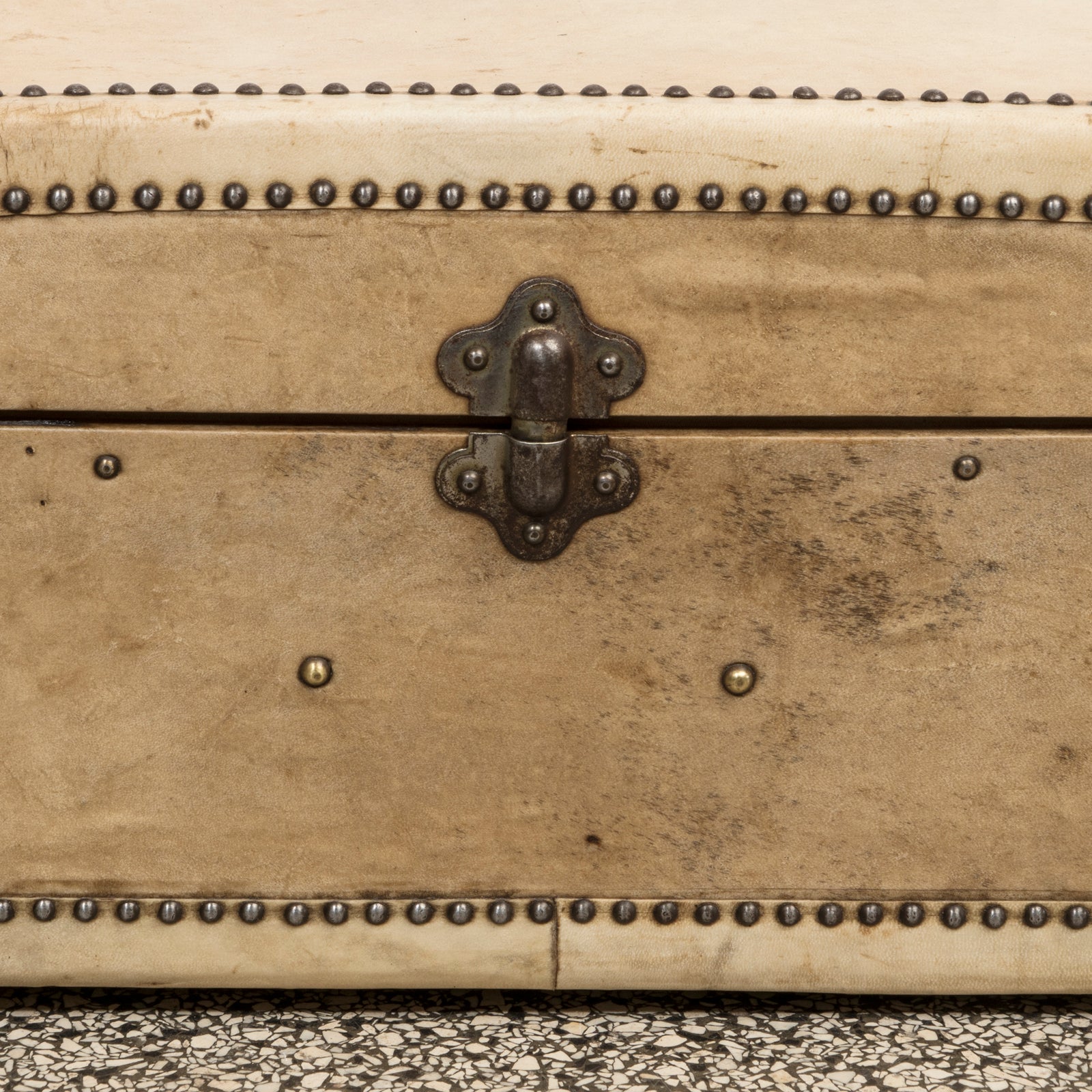 Close-up of a vintage French cream leather suitcase with brass studs