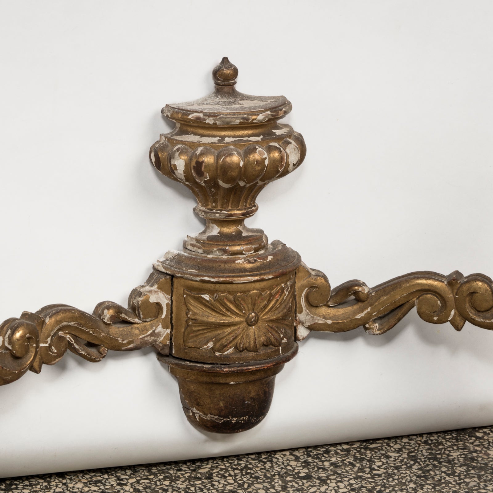 Close-up of a highly decorative antique French Louis XV style gilt wood console table with a white marble top, featuring intricate gilded designs and resting on carved legs. Showing some age appropriate wear and original patina.