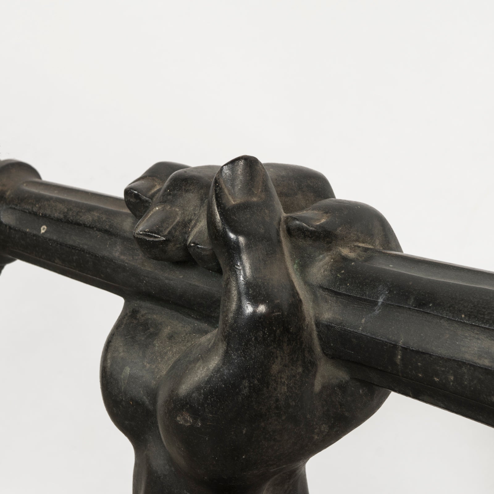 Close-up of a heavy antique French iron wall bracket, finely cast as an outstretched arm holding a torch, shown against a clean background.