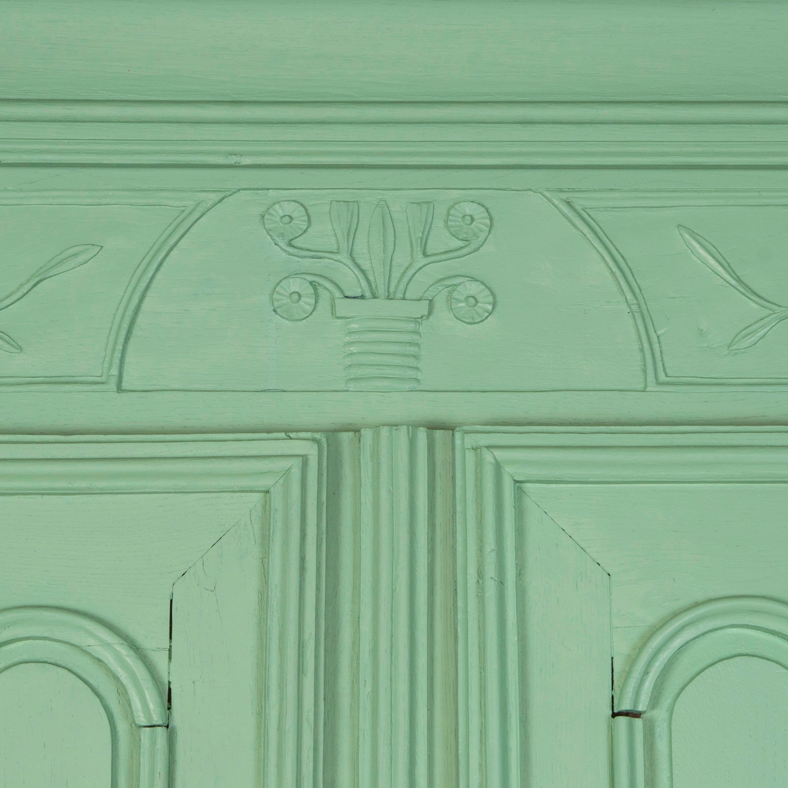Close-up of a 19th-century green French marriage armoire with carved foliage motifs from Wildschut Antiques