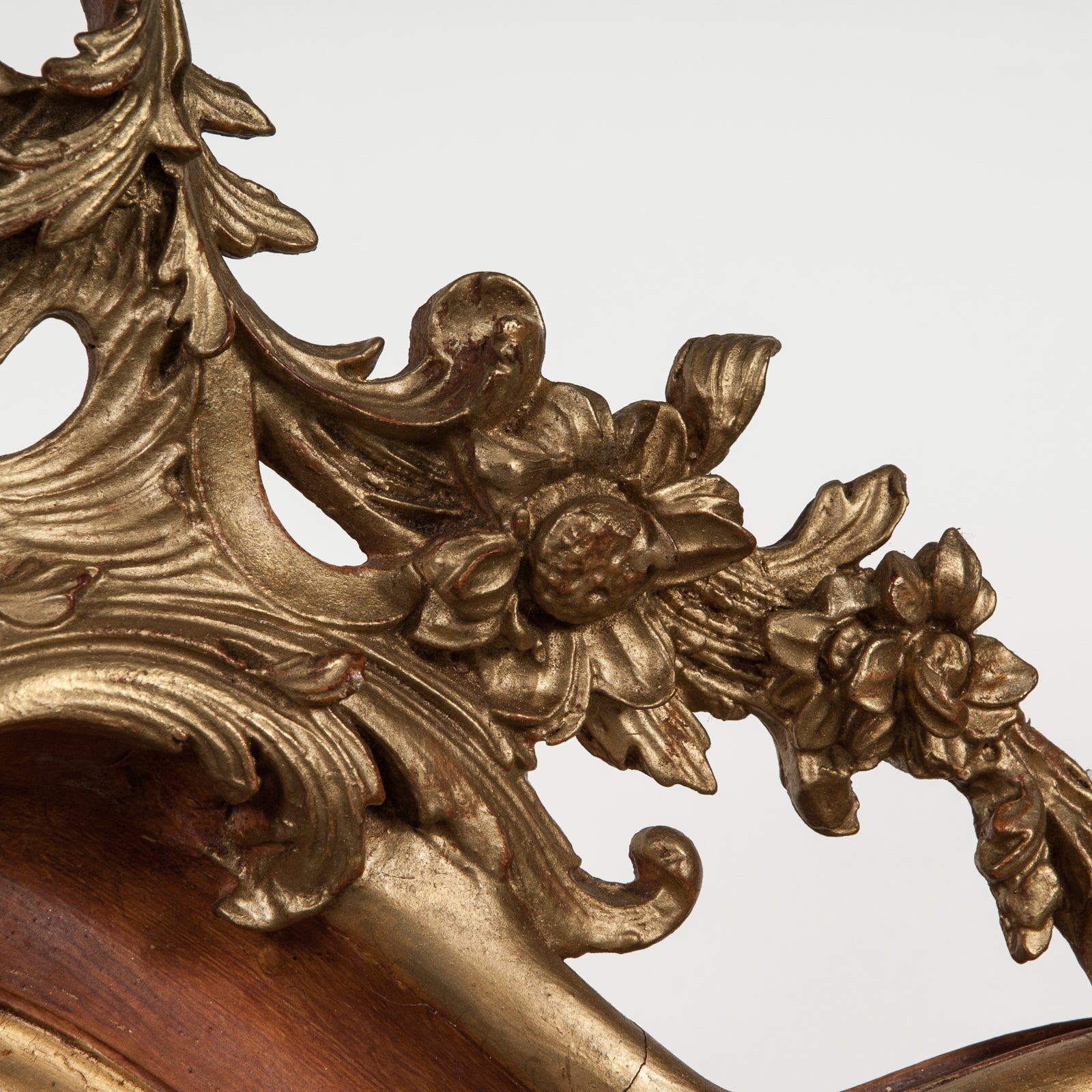 Close-up of the crest of a 19th century Italian Rococo style gilt wood mirror with floral decoration and a scalloped shell in the frame, available at Wildschut Antiques