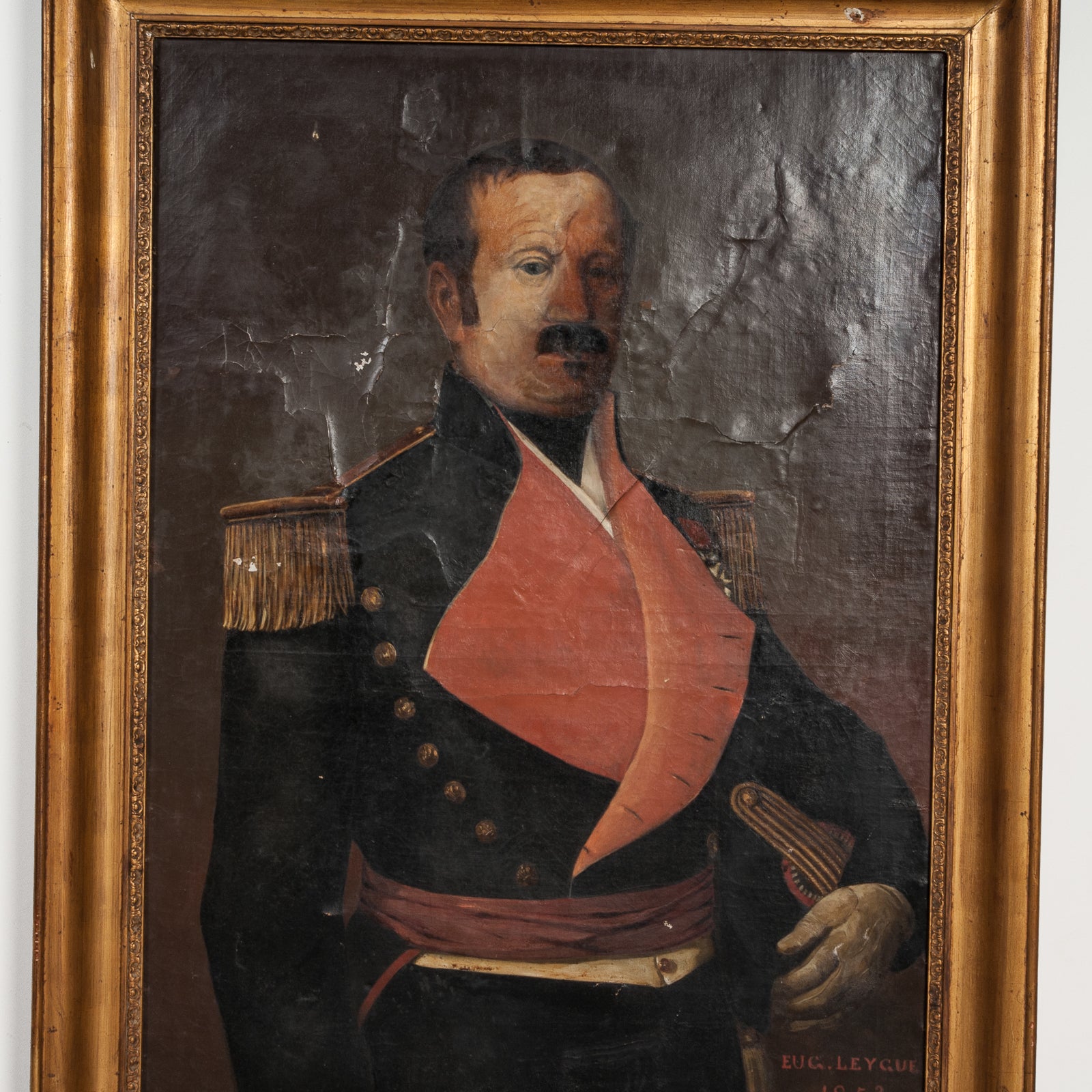 Close-up of a 19th C Portrait of a French Military Man wearing a dark blue jacket with a red lapel, signed by Eug. Leycuf, oil on canvas, framed in a giltwood frame.