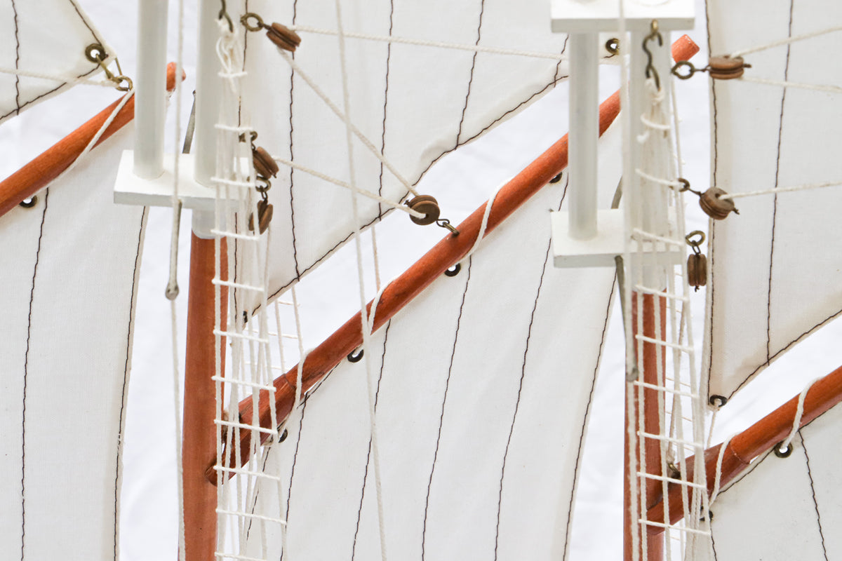 Close-up of a vintage Marco Polo sail boat model with white sails