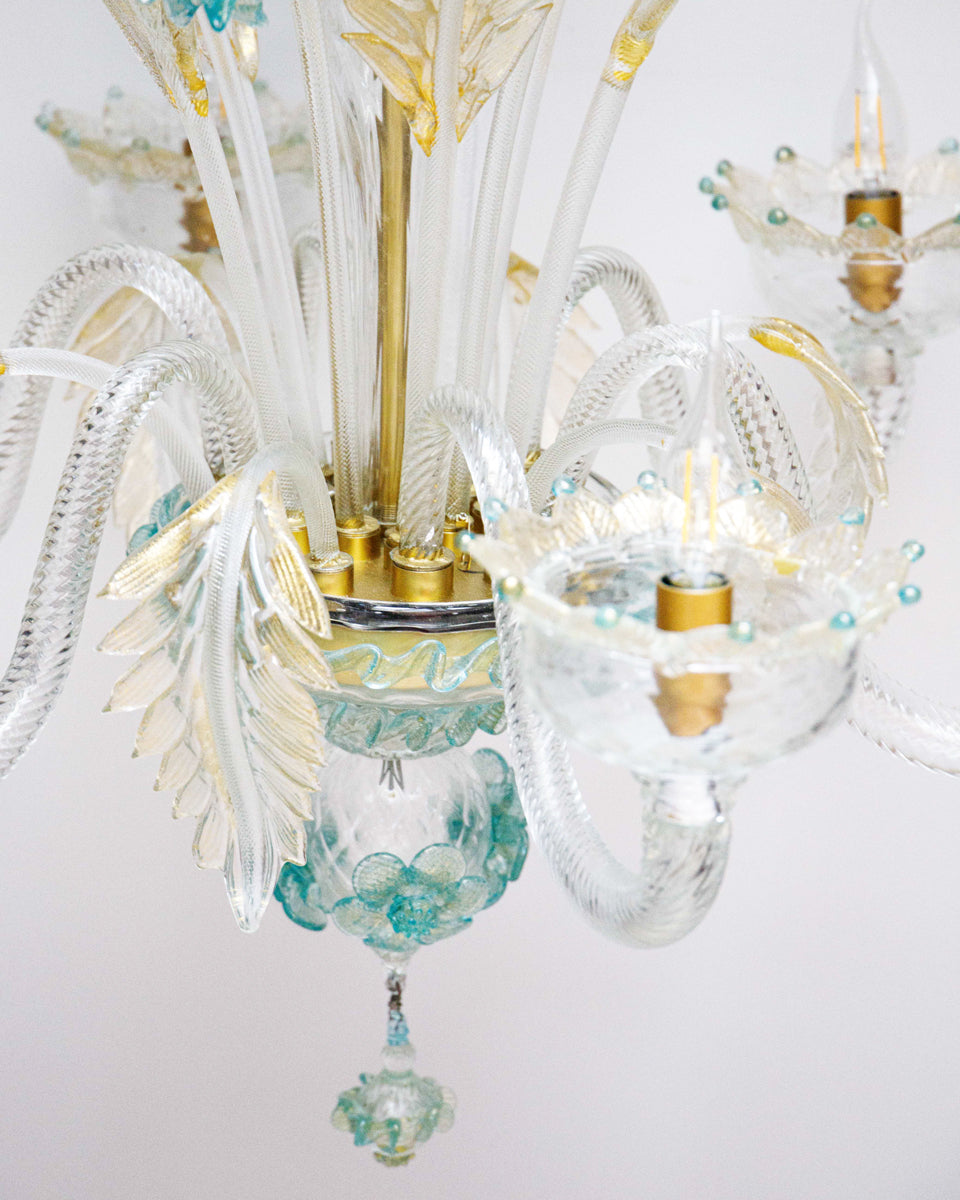 Close-up of a Venetian Murano glass 6-light chandelier with white glass and blue and gold details, featuring intricate floral patterns