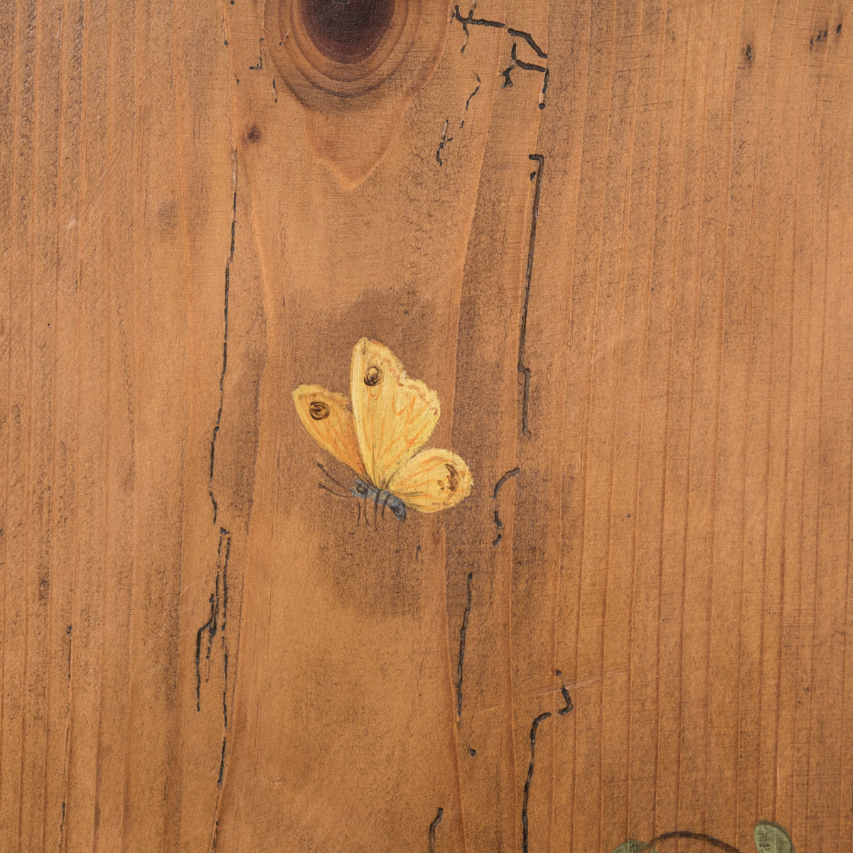 Close-up of a charming antique French tall case clock with a painted pine case decorated with floral motifs and a yellow butterfly