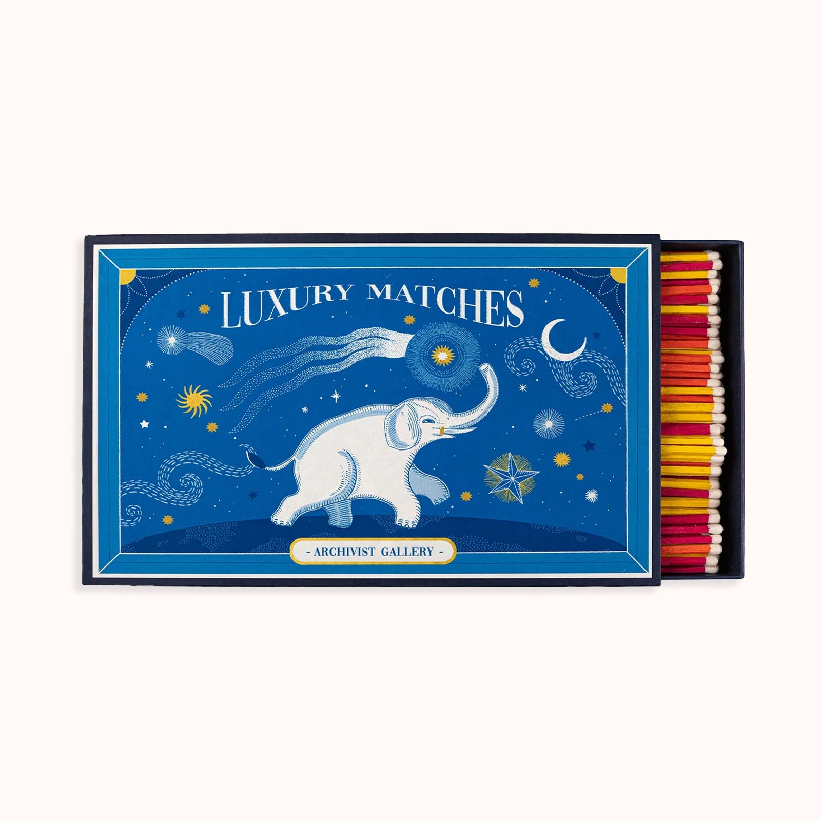 A large blue matchbox with a fairy-tale illustration of an elephant among the stars and the moon. The box is open, showing colorful matches inside. Part of the Archivist Gallery Collection, available at Wildschut Antiques.