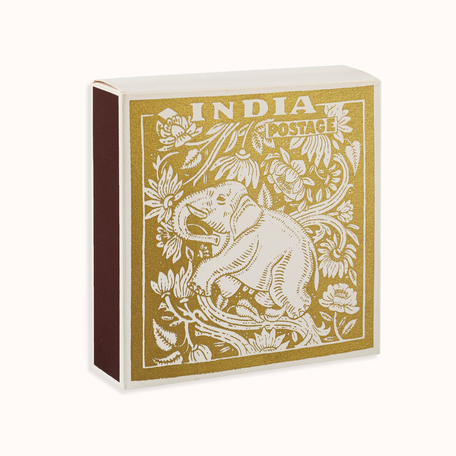 A gold matchbox with a vintage stamp design featuring an elephant, part of the Archivist Gallery collection, available at Wildschut Antiques