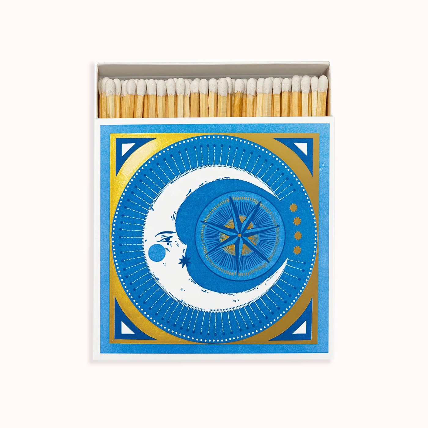 A matchbox with a blue and gold color scheme featuring a crescent moon and stars design. Part of the Archivist Gallery Collection, available at Wildschut Antiques.