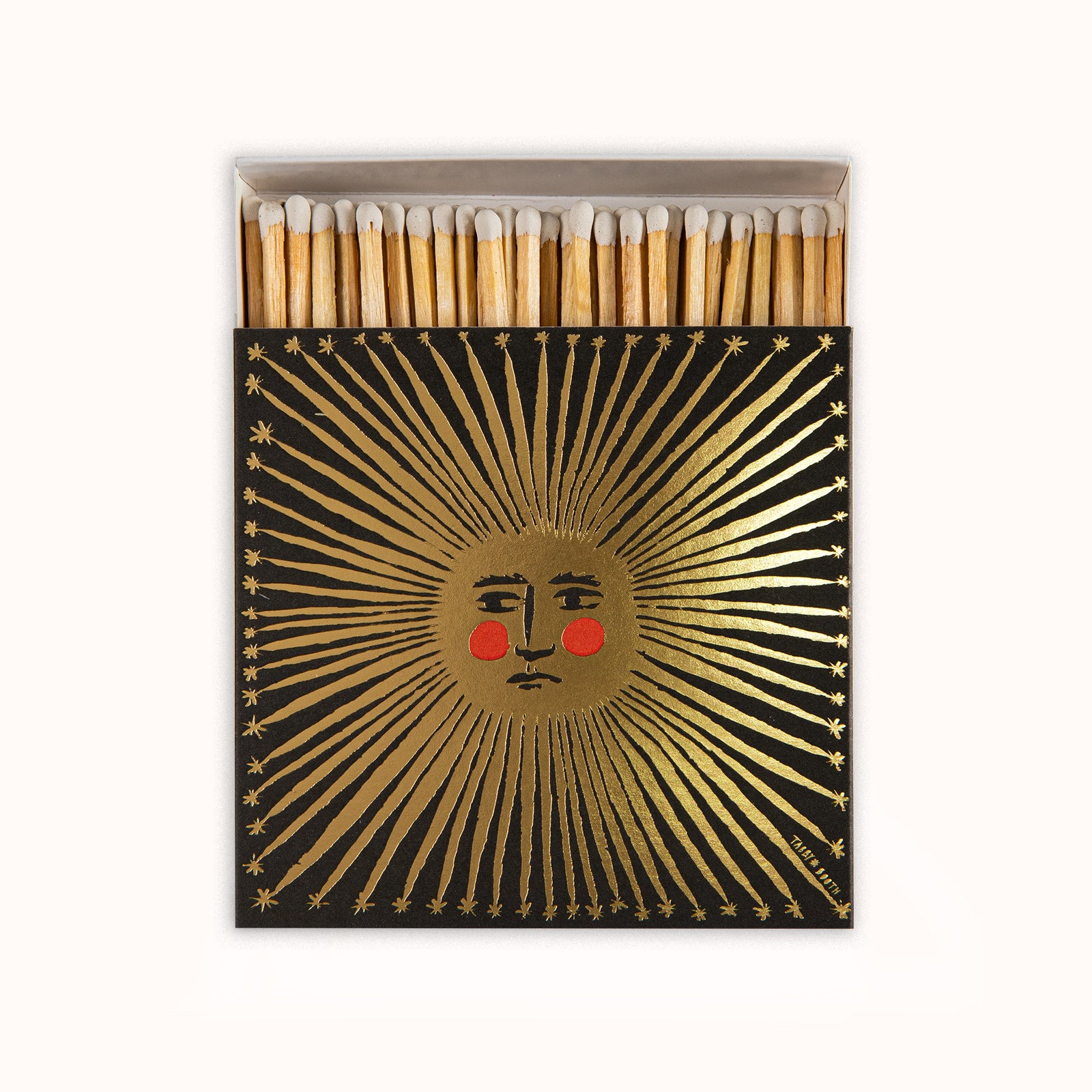 Matches in a decorative Archivist Gallery matchbox featuring a golden sun motif, displayed on a white background, available at Wildschut Antiques.