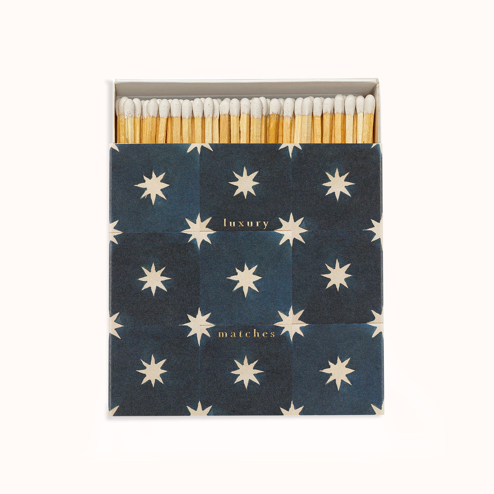 A navy blue matchbox with white star patterns and the text 'luxury matches' on the cover. Part of the Archivist Gallery Collection, available at Wildschut Antiques.