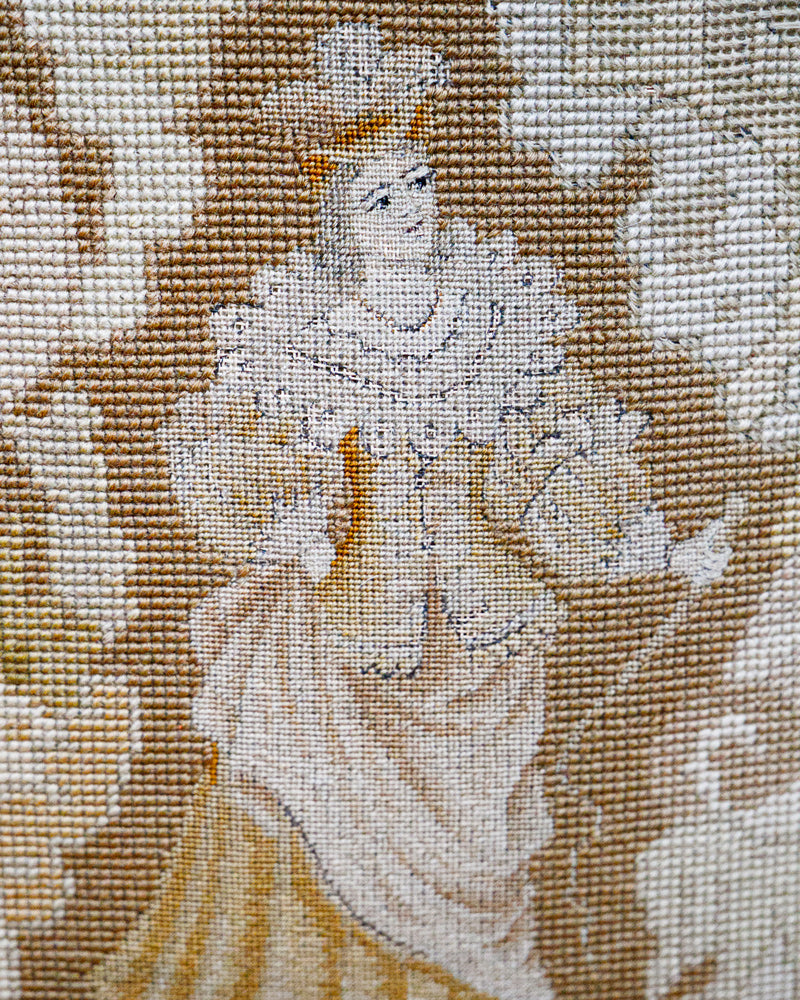 Embroidered panel of a woman in a historical dress with a crown on a textured fabric background
