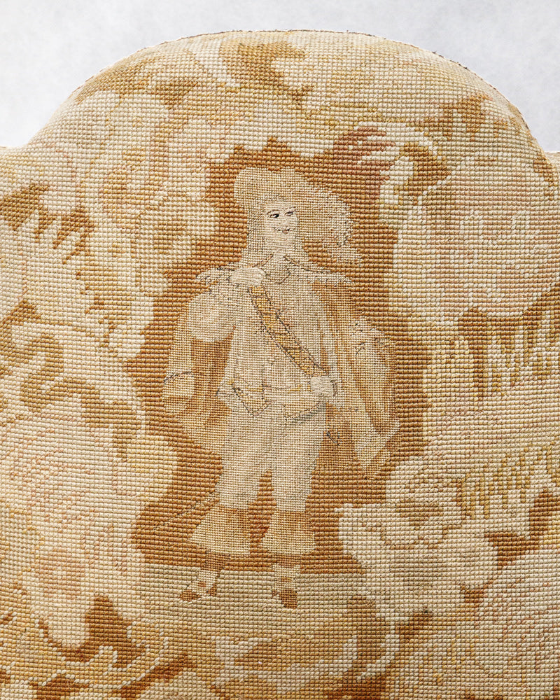 Close-up of embroidered Aubusson tapestry fabric with a person in historical attire and landscape design.