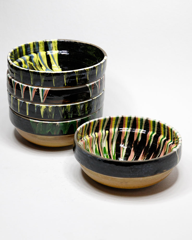Set of black ceramic bowls with colorful marbled stripe patterns on a white background. Available at Wildschut Antiques.