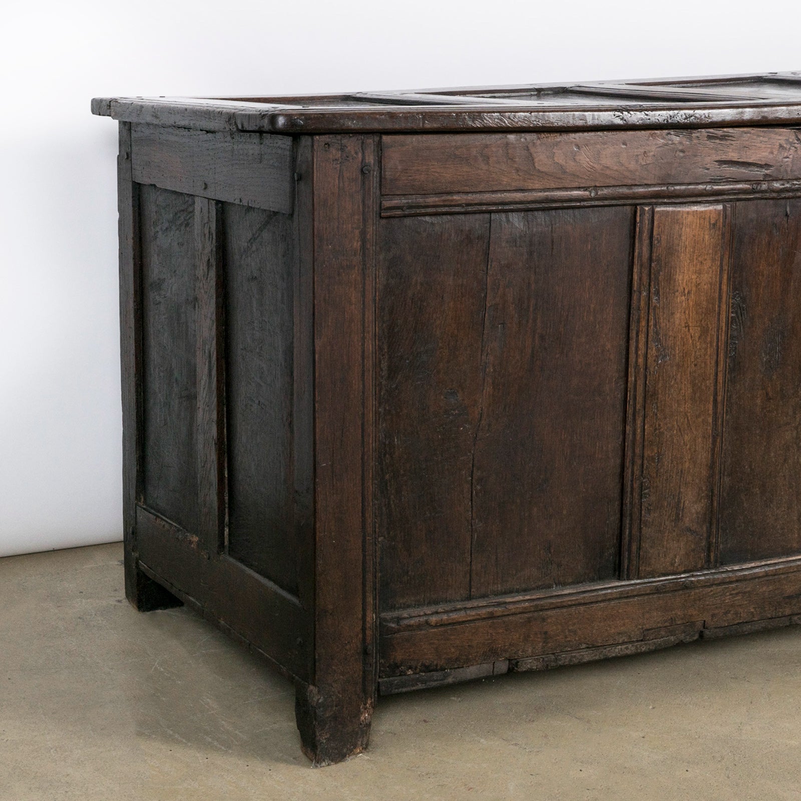 Close-up of an antique early 18th-century solid oak chest or coffer, paneled and carved in warm brown tones. Available at Wildschut Antiques.