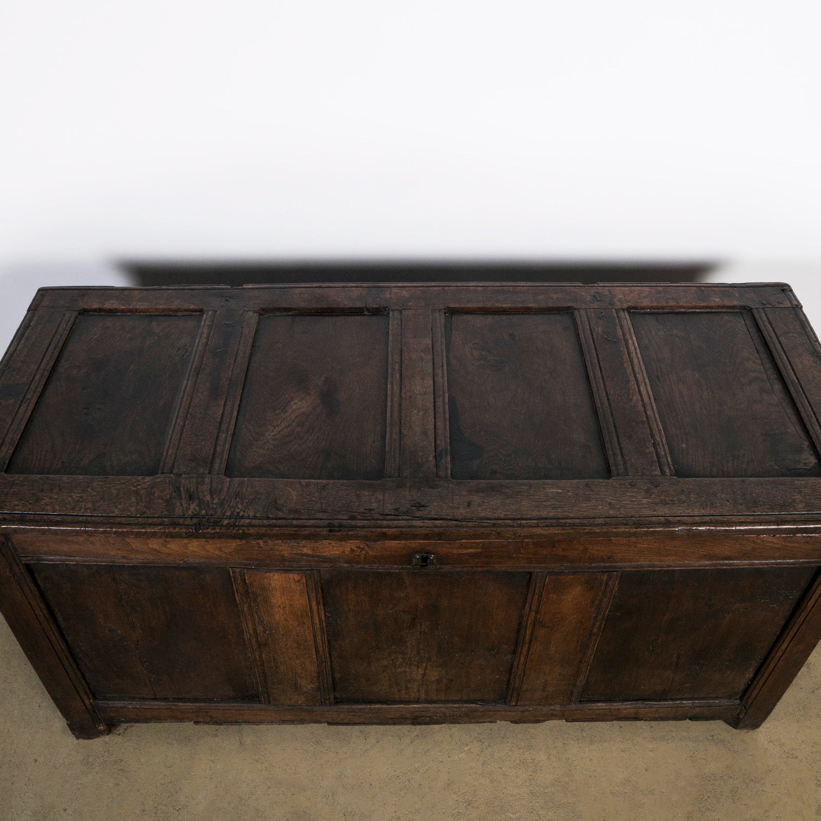 Top view of an antique early 18th-century solid oak chest or coffer, paneled and carved in warm brown tones. Available at Wildschut Antiques.