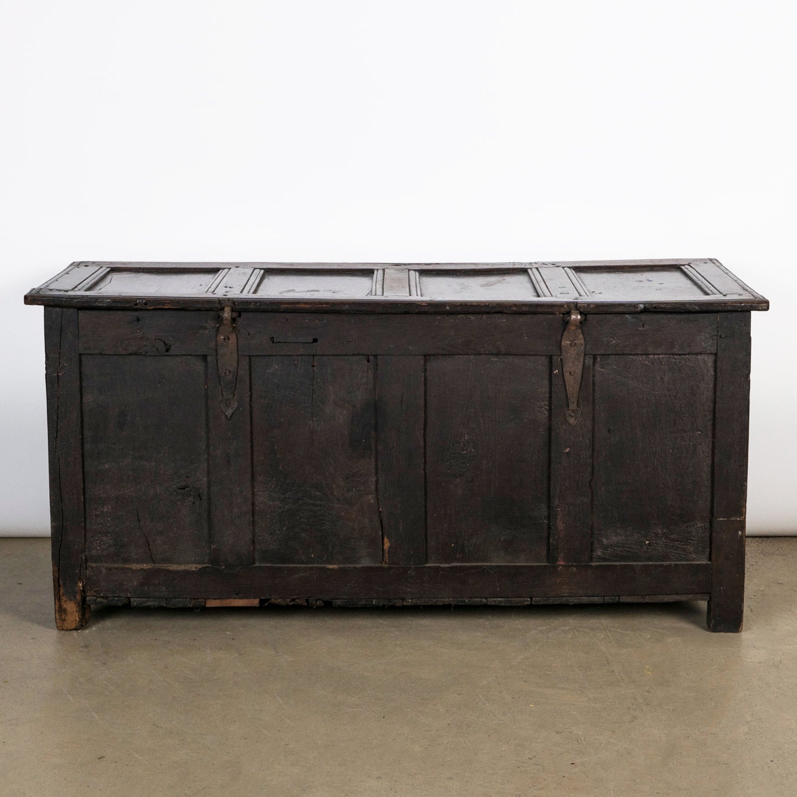 Backside of an antique early 18th-century solid oak chest or coffer, paneled and carved in warm brown tones. Available at Wildschut Antiques.