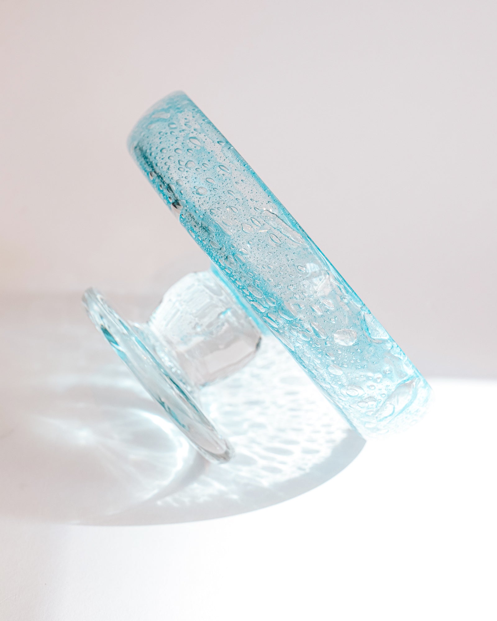 Side view of a vintage round blue glass fruit bowl resembling a heavy glass droplet, likely by Biot, France.
