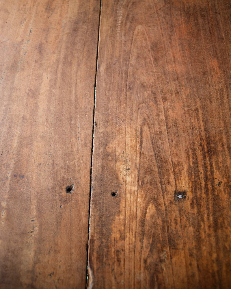 Close-up of a long vintage French wooden table with a blue painted base and a natural wood top