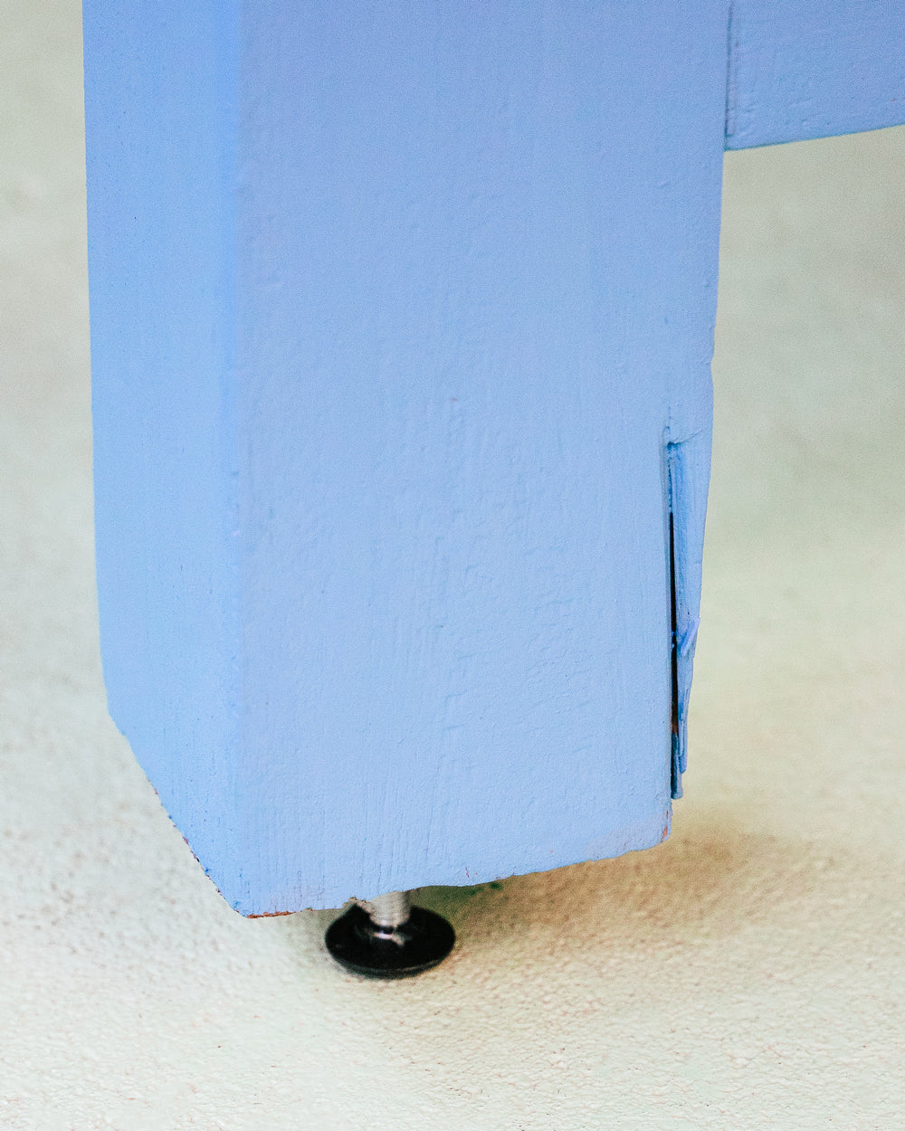 Close-up of a long vintage French wooden table with a blue painted base and a natural wood top