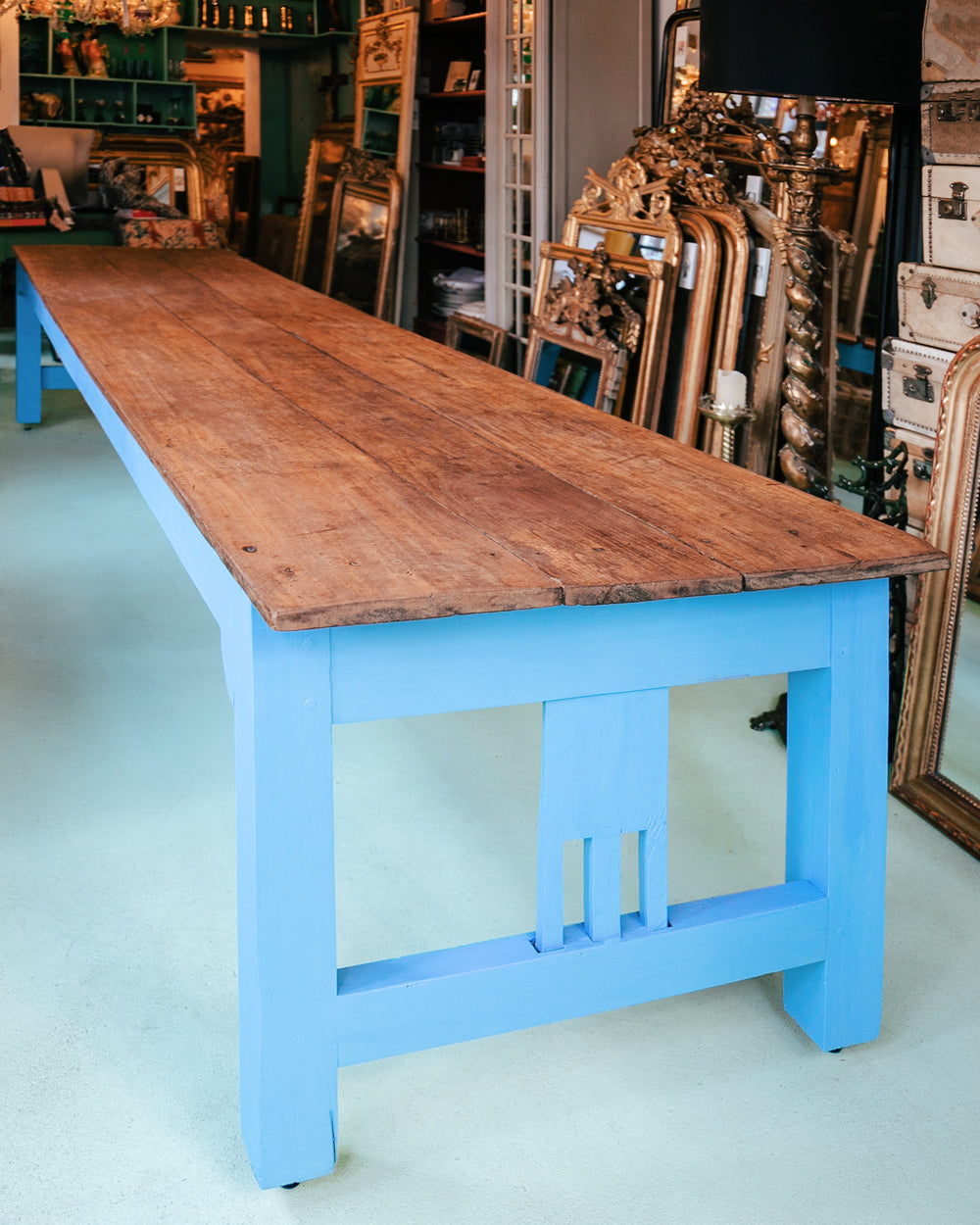 Close-up of a long vintage French wooden table with a blue painted base and a natural wood top, available at Wildschut Antiques