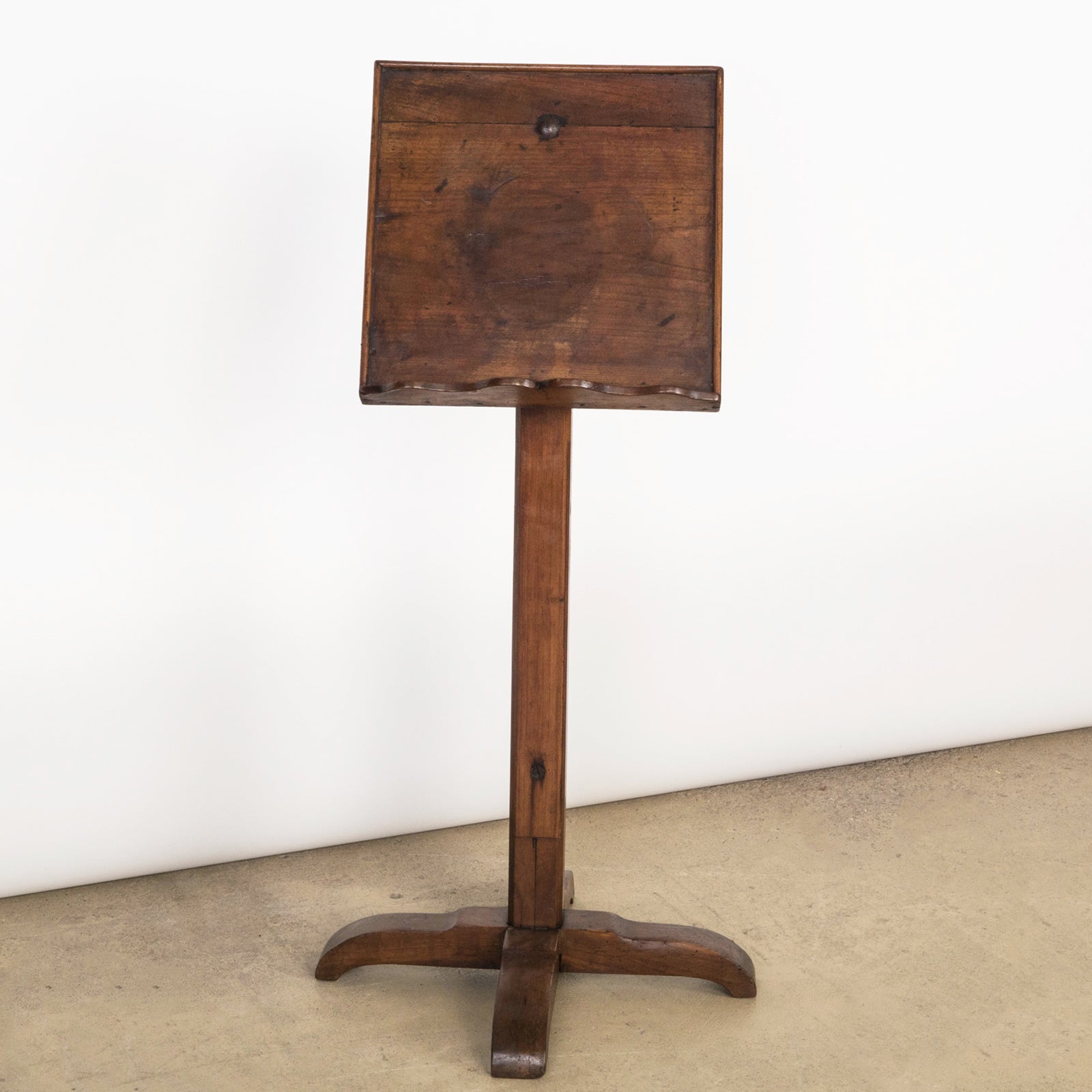 An antique wooden reading stand or book stand with an adjustable top and a rectangular base