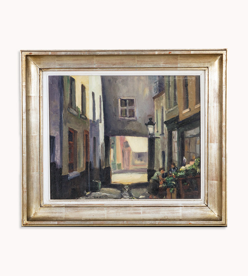 An oil painting depicting a narrow street in Brussels with houses and a small grocery stand, signed by F. Jorwitz and encased in a 1950s-60s style frame, available at Wildschut Antiques