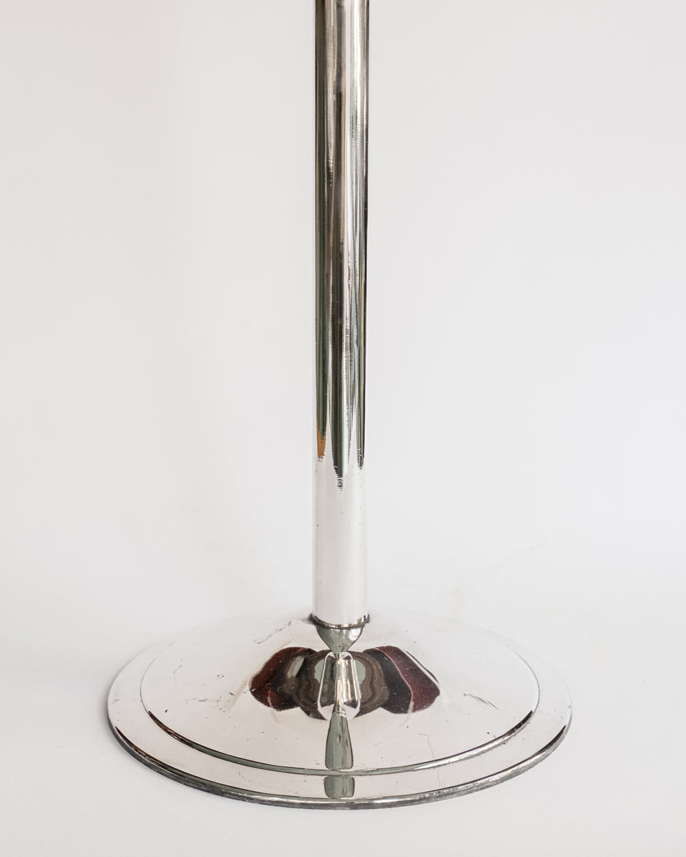 Close-up of a vintage silver plated champagne bucket stand, with a sleek, cylindrical shape and a reflective surface