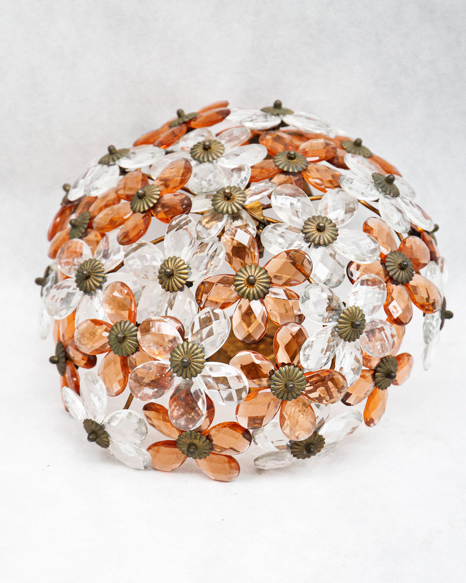 Decorative vintage ceiling lamp with orange and clear glass prisms in the shape of flowers on a white background