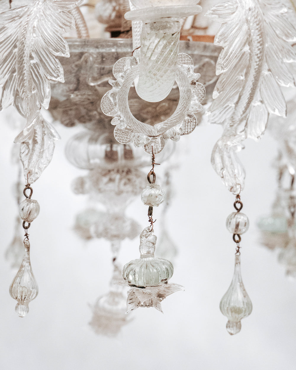 Close-up of a clear, hand-blown glass Venetian chandelier with six lights and intricate details