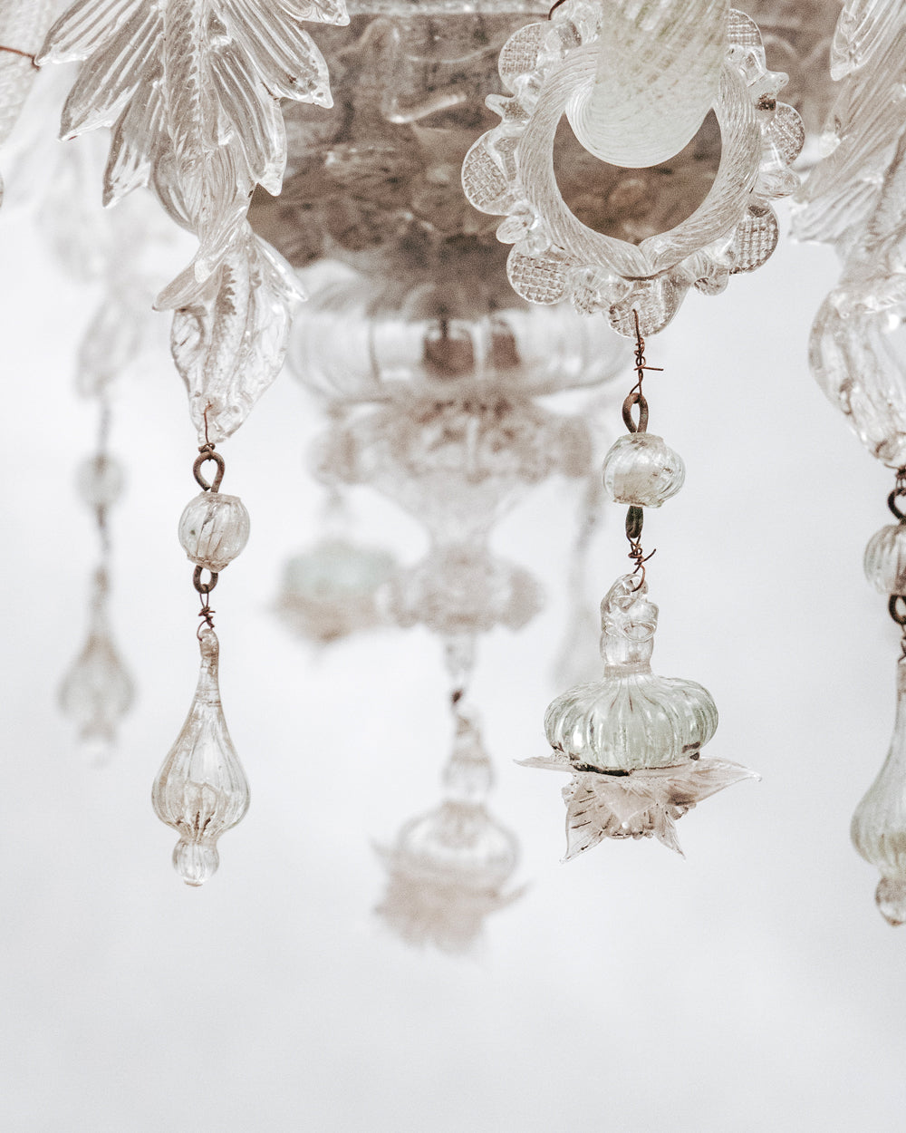 Close-up of a clear, hand-blown glass Venetian chandelier with six lights and intricate details