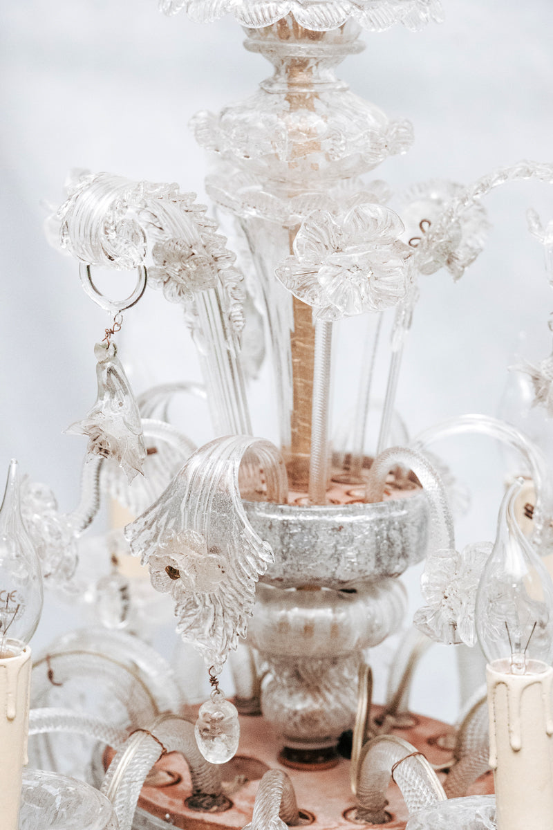 Close-up of a clear, hand-blown glass Venetian chandelier with six lights and intricate details