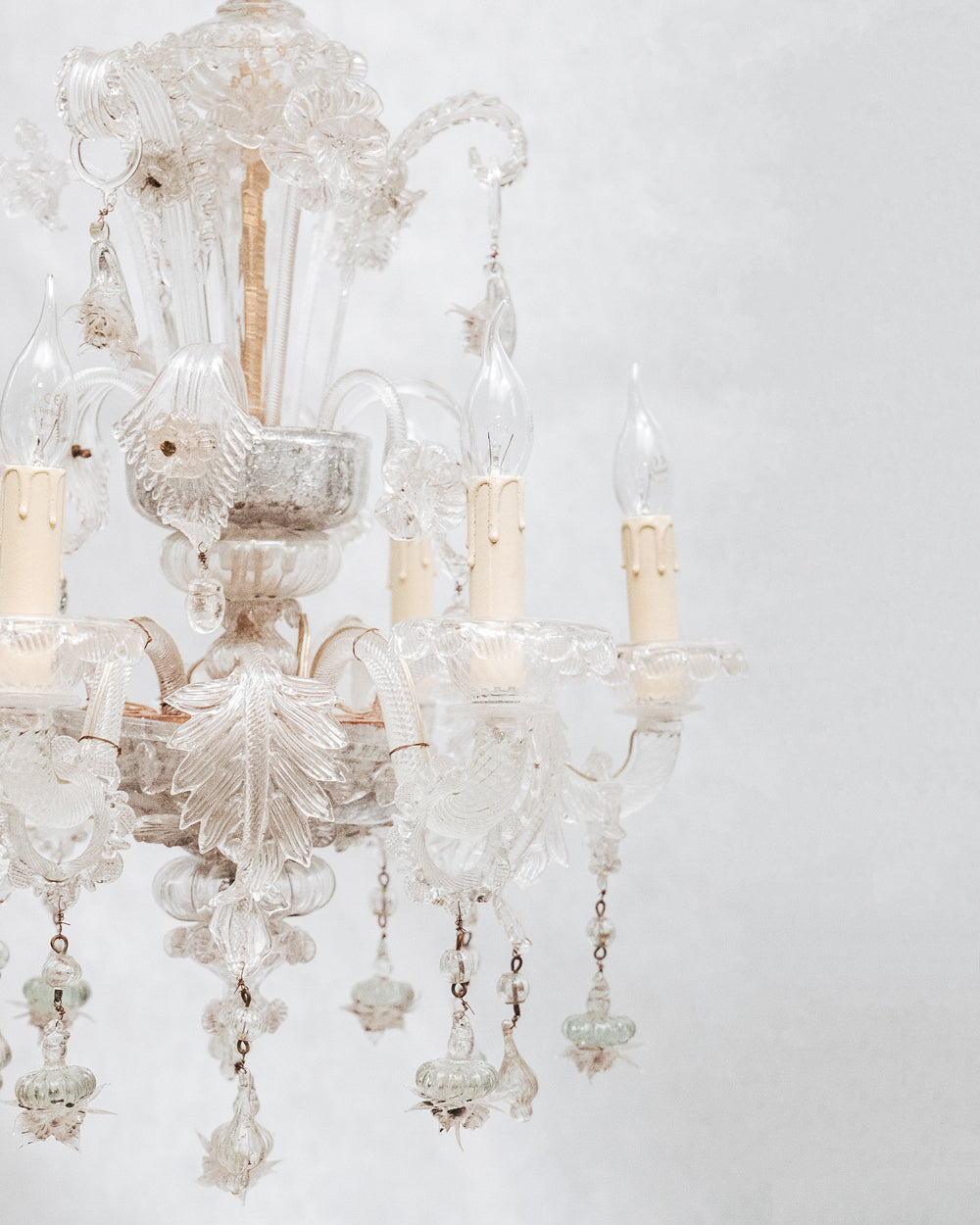 Close-up of a clear, hand-blown glass Venetian chandelier with six lights and intricate details