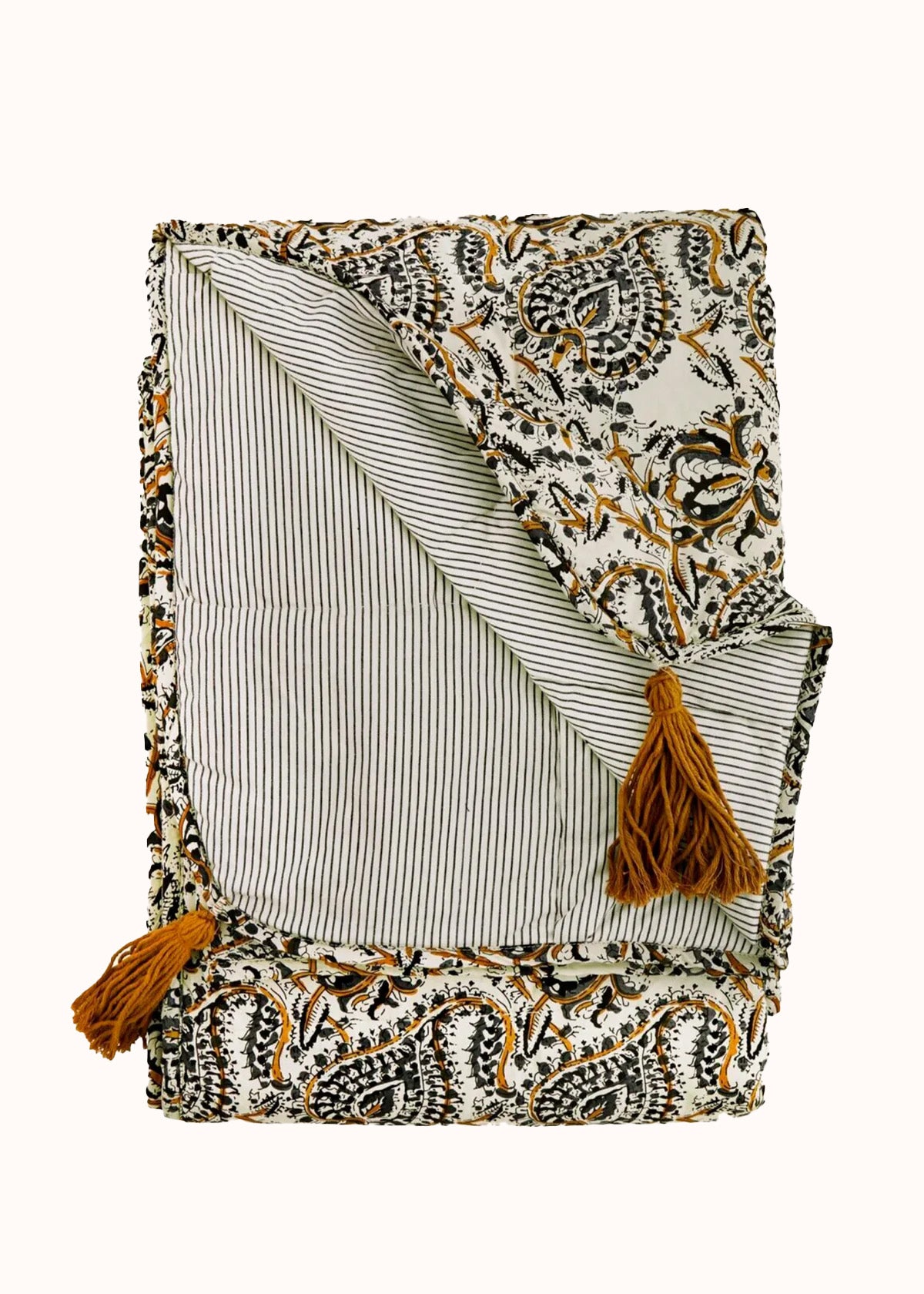 Floral and paisley printed cotton blanket with striped reverse and finished with ochre cotton tassels. Elegantly folded against a clean background—available at Wildschut Antiques.