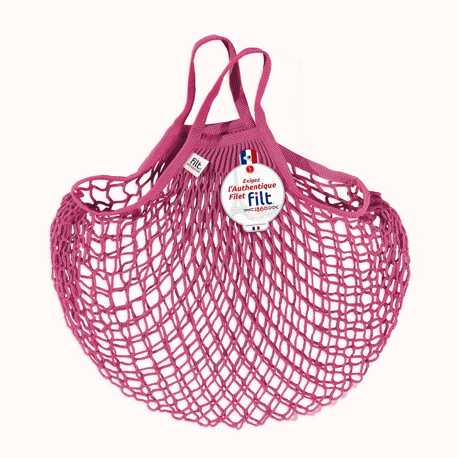Pink mesh shopping bag with 'filt 1860' label on a white background