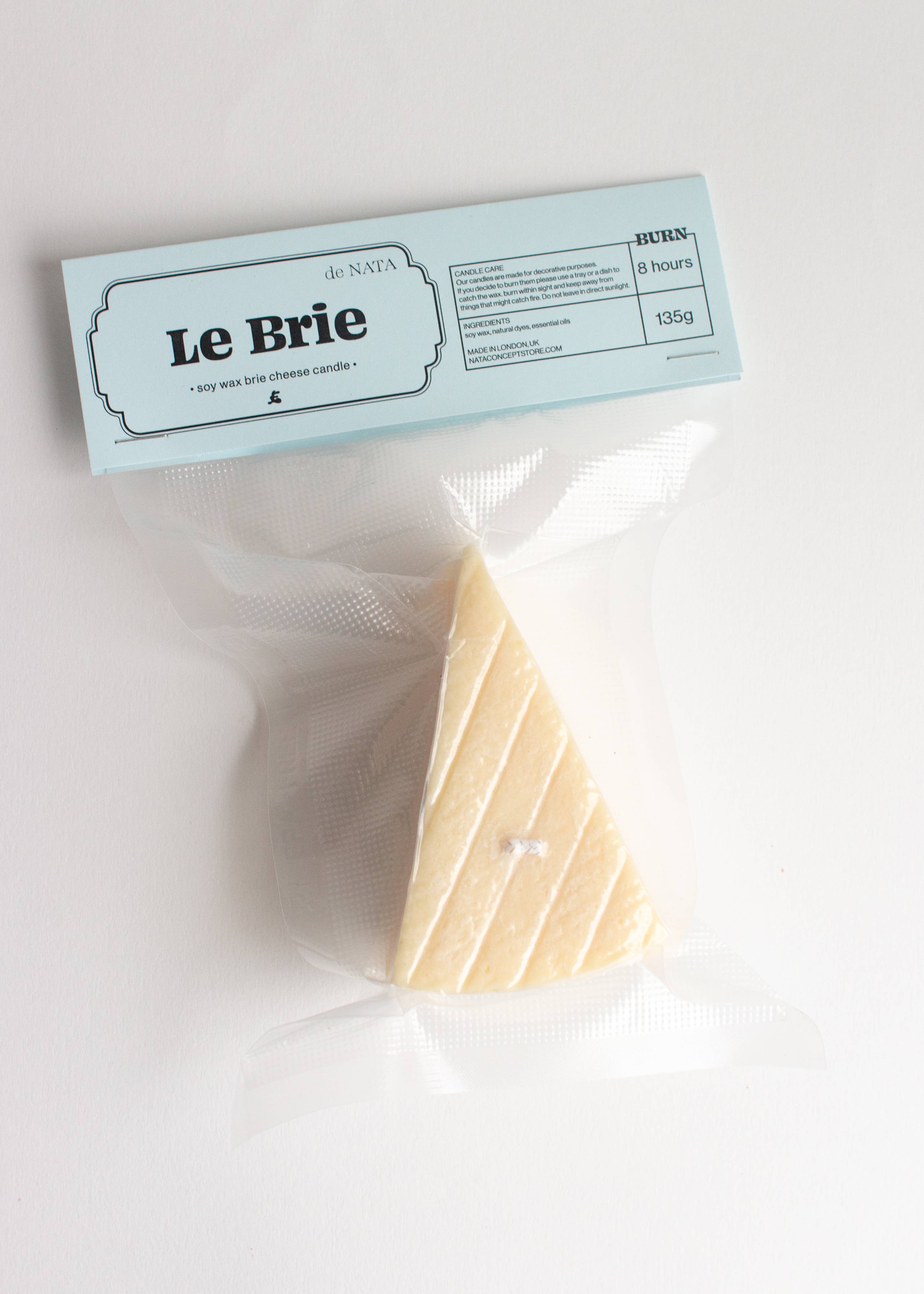 Packaged cheese with 'Le Brie' label on a white background. Fun fact: this is not a real piece of brie, it is a candle! Part of the Playful Food Candle Collection available via Wildschut Antiques Concept Store