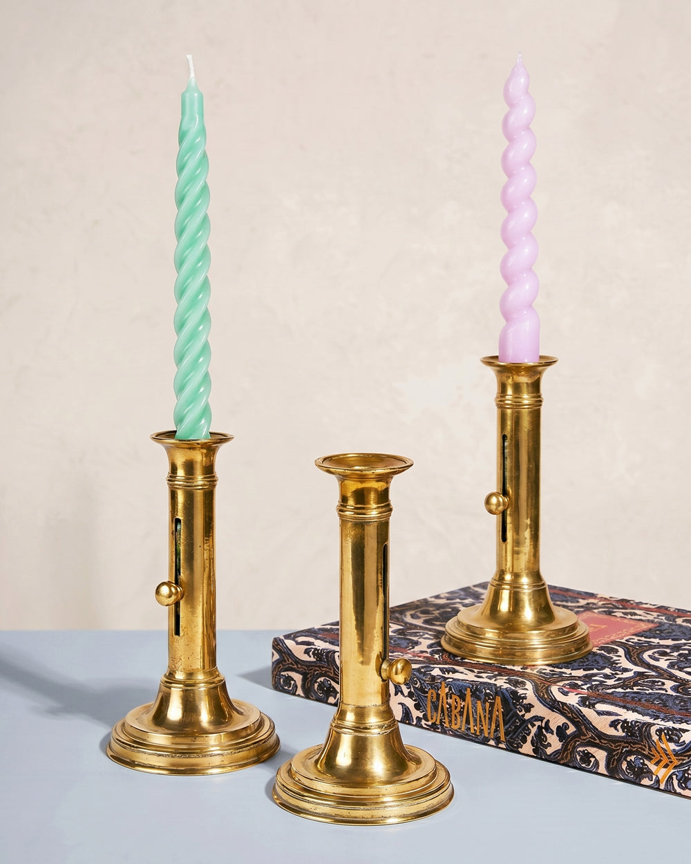 Three antique French brass candlesticks with twisted candles. Available at Wildschut Antiques.