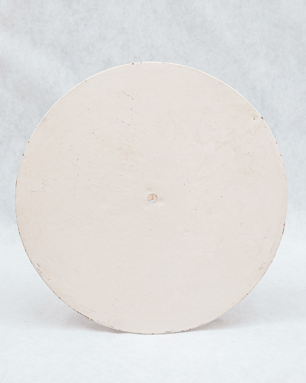 Top view of a vintage early 20th-century French folding metal round garden table with a patinated iron frame set against a white background.