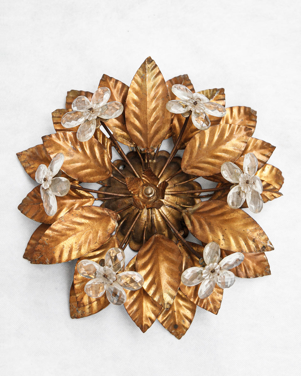 Decorative vintage French wall or ceiling lamp with gold leaf and crystal flower design on a white background available at Wildschut Antiques