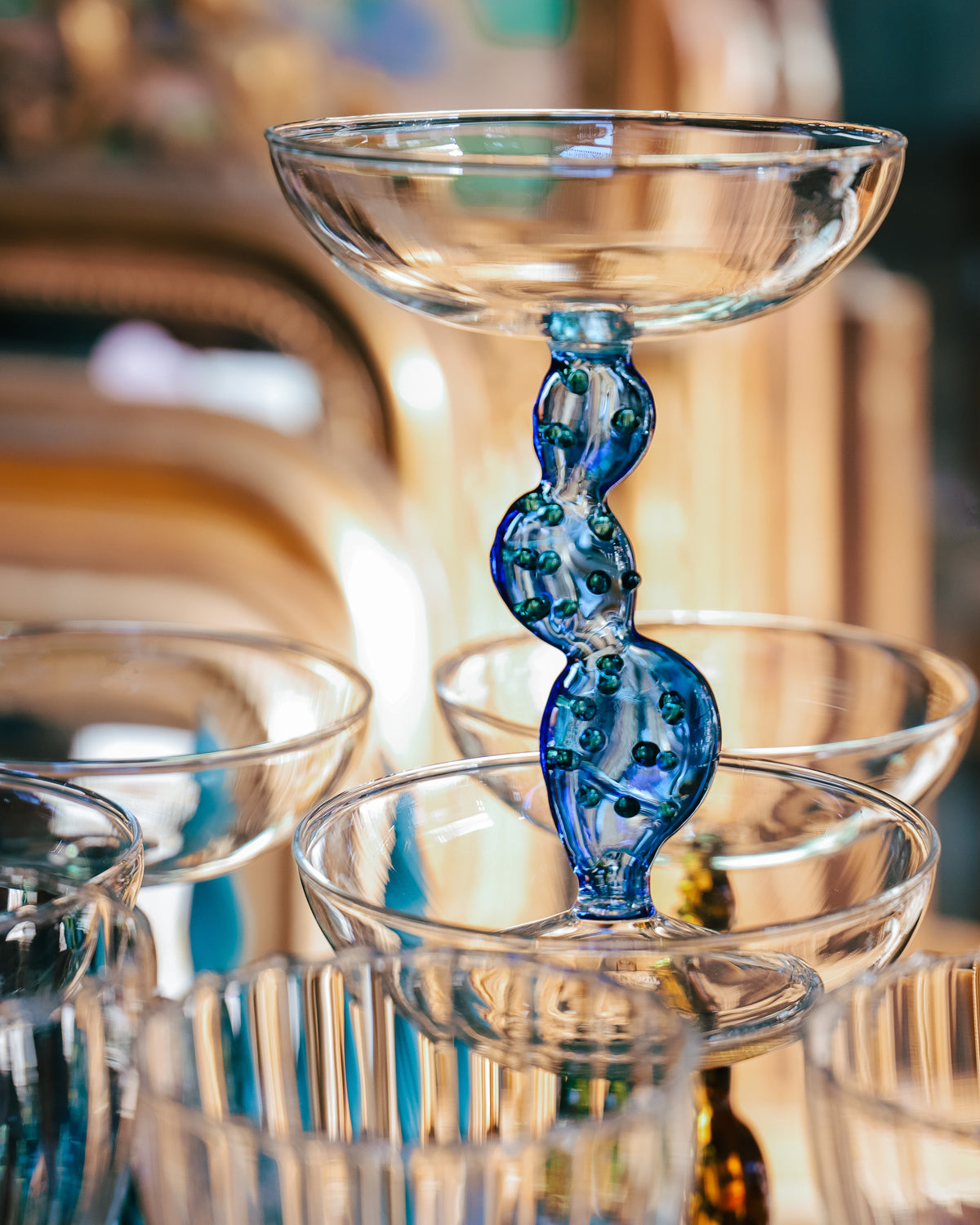A champagne coupe glass with a transparent blue-colored stem designed to resemble cactus leaves, by Ichendorf Milano, photographed in the Wildschut Antiques store