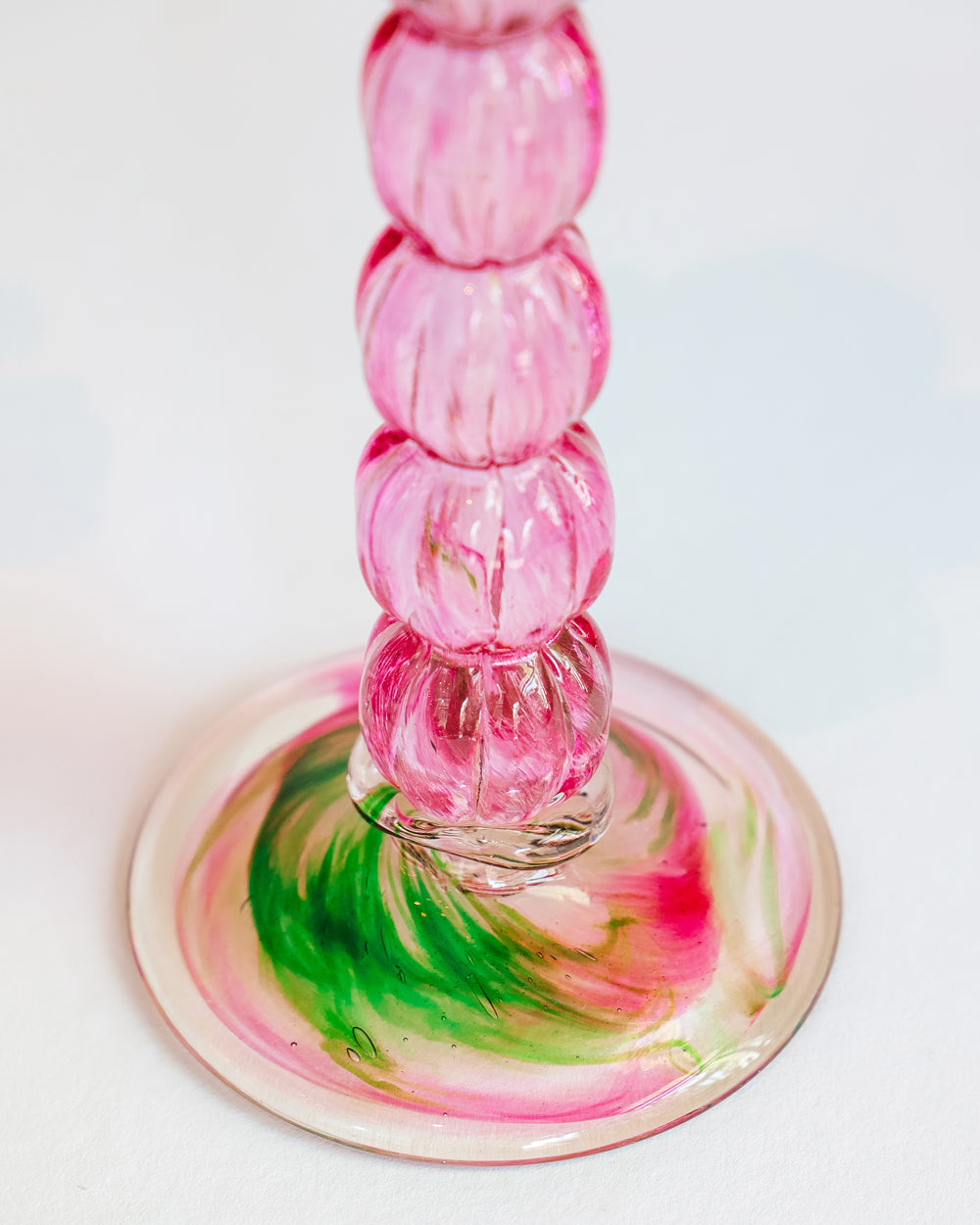Close-up of a vintage Murano glass palm tree candle holder in green and pink colors