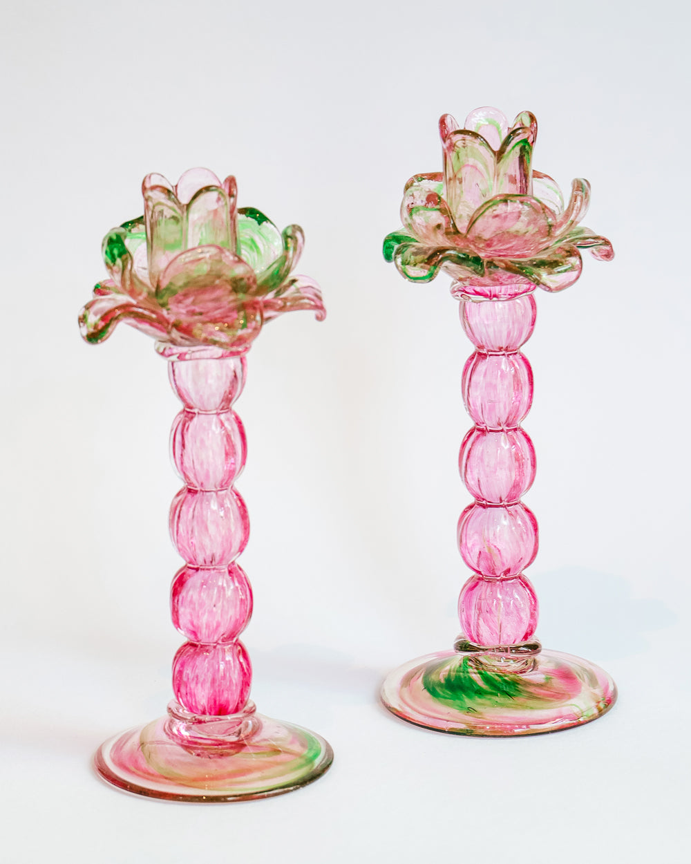 A vibrant pair of vintage Murano glass palm tree candle holders in green and pink colors, available at Wildschut Antiques
