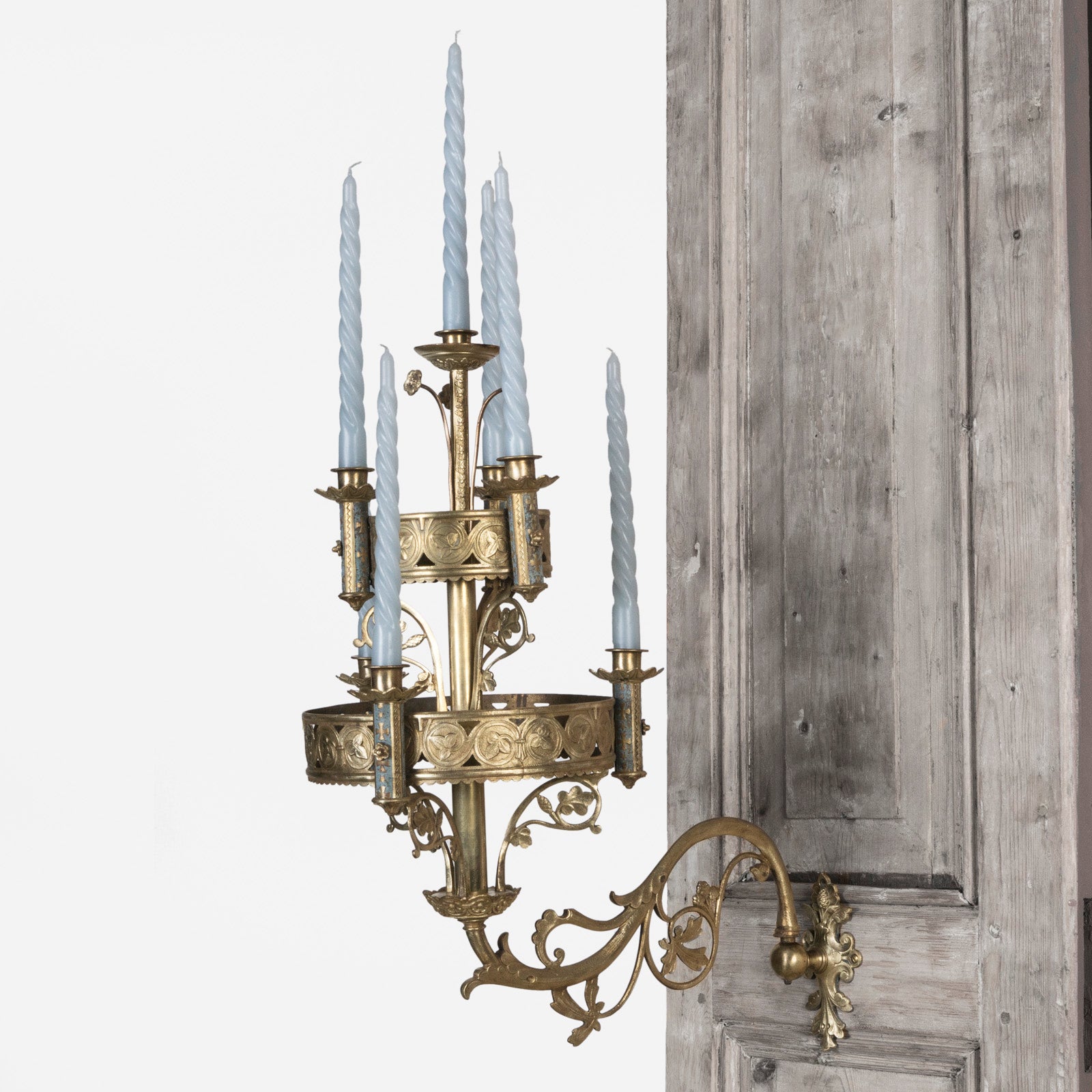 A 19th century Gothic style candle sconce with gold-colored metal mountings and light blue swirl candles, designed for wall mounting, available at Wildschut Antiques