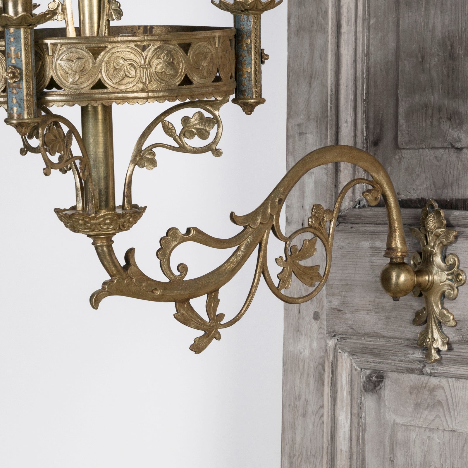 Close-up of a 19th century Gothic style candle sconce with gold-colored metal mountings and light blue swirl candles, designed for wall mounting, available at Wildschut Antiques