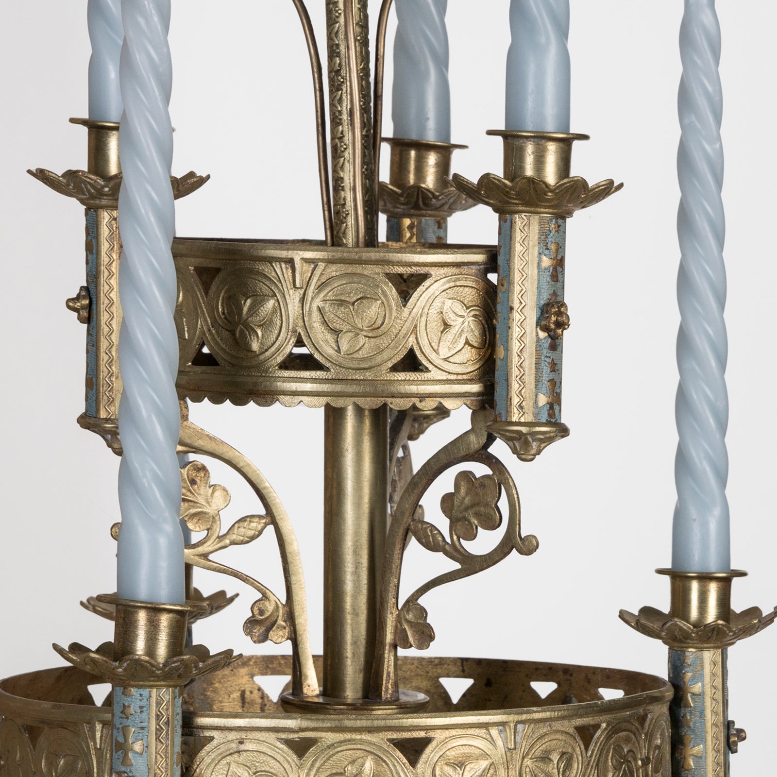 Close-up of a 19th century Gothic style candle sconce with gold-colored metal mountings and light blue swirl candles, designed for wall mounting, available at Wildschut Antiques