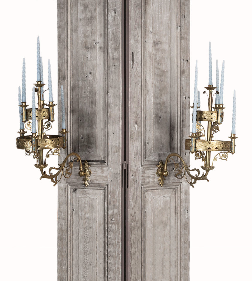 A pair of 19th century Gothic style candle sconces with gold-colored metal mountings and light blue swirl candles, designed for wall mounting, available at Wildschut Antiques