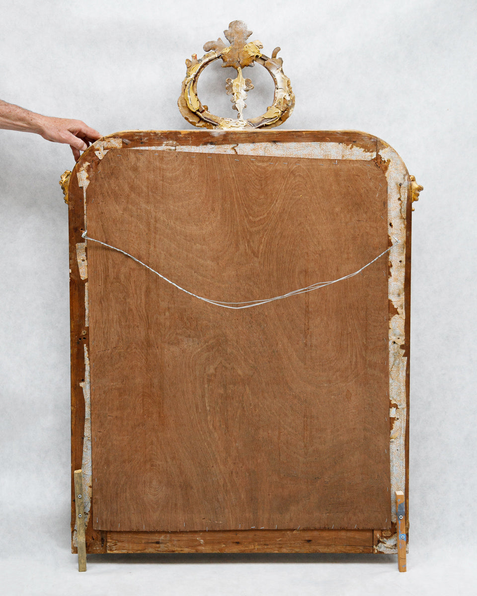 Backside of an antique mirror with decorative elements on a white background